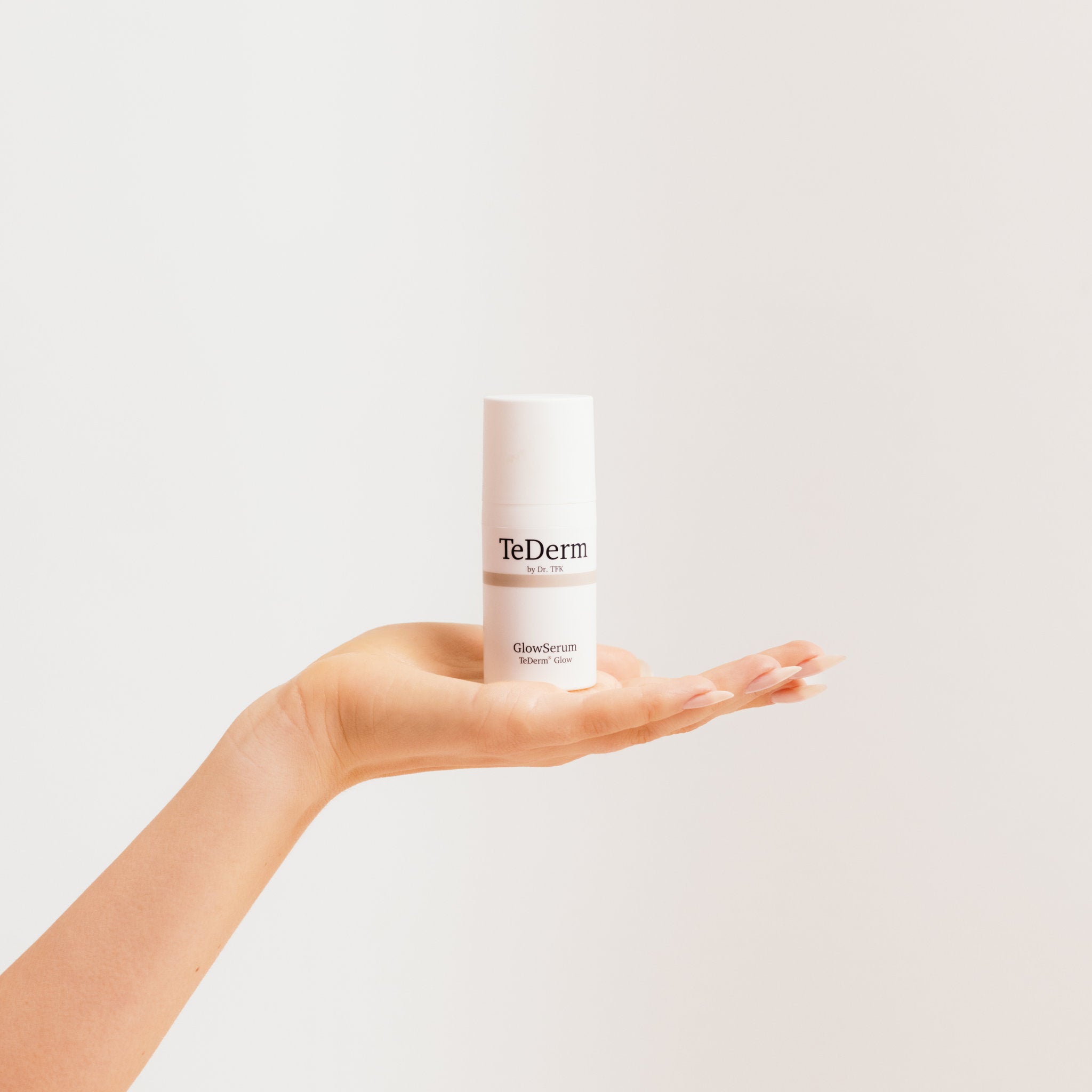 Hands holding TeDerm GlowSerum – daily serum care