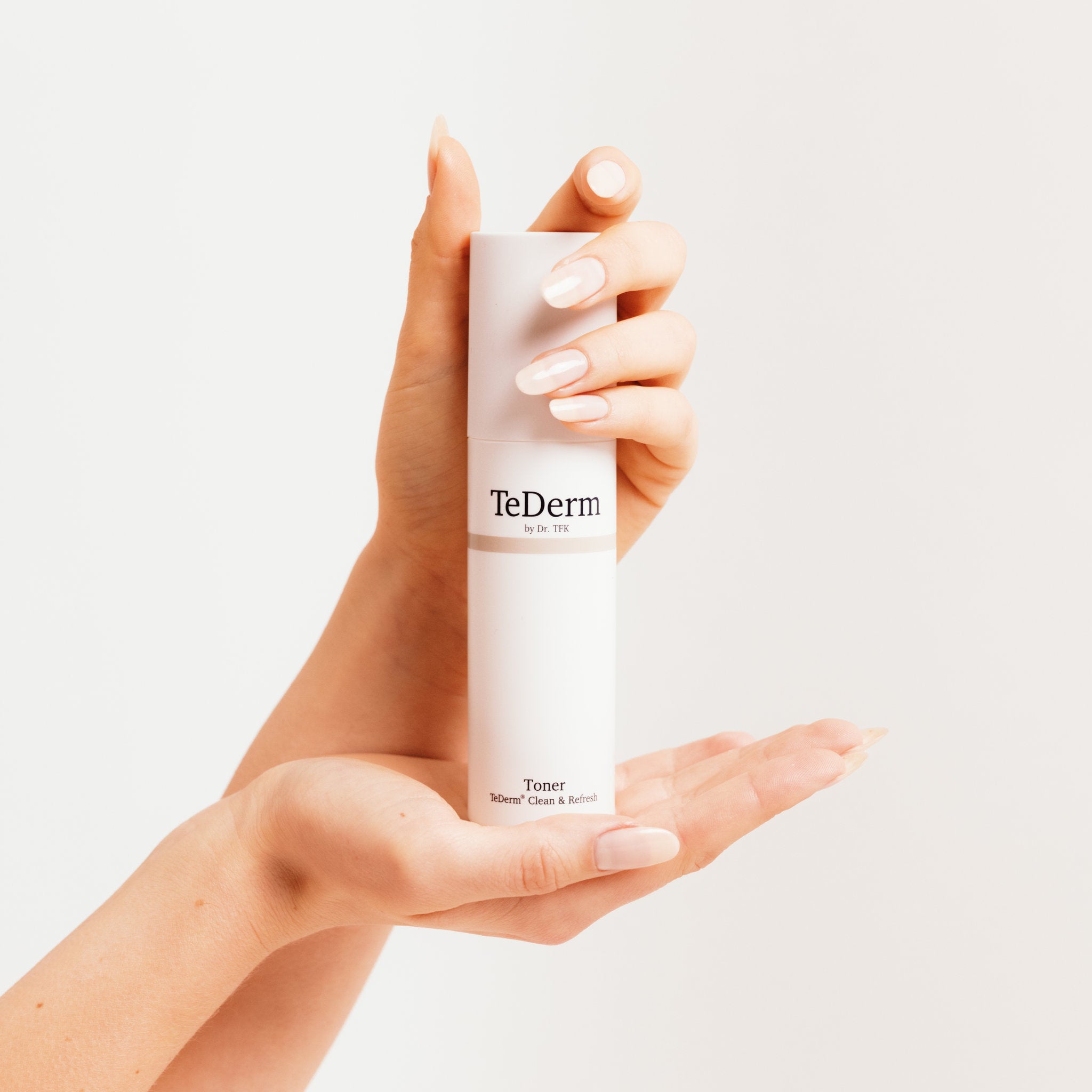 Hands holding TeDerm Toner – daily toner application